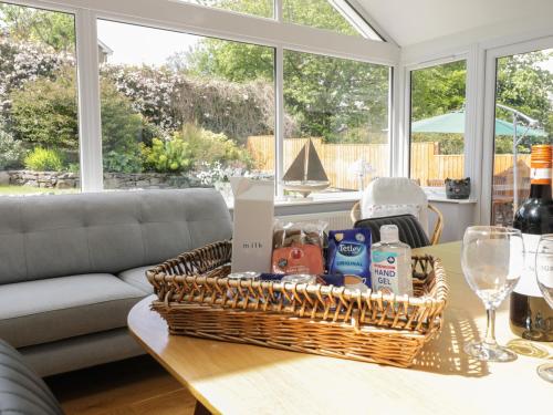 a basket of food on a coffee table in a living room at Clyd Fan in Harlech