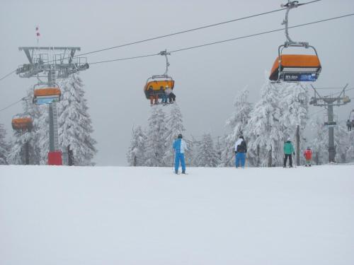 a group of skiers on a ski lift at Apartments Klinovec in Loučná pod Klínovcem