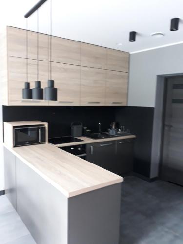 a kitchen with wooden cabinets and a counter top at Boszkowo Makowa Cisza in Boszkowo