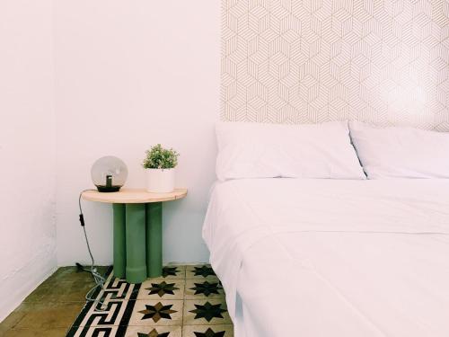 1 dormitorio con 1 cama y 1 mesa con lámpara en Maria Magdalena - Room 8, en Málaga