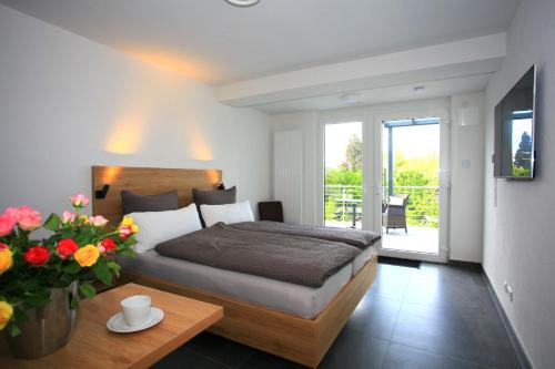 - une chambre avec un lit et une table ornée d'un vase de fleurs dans l'établissement Überlinger See-Apartments Apartment 8 Über-See, à Überlingen