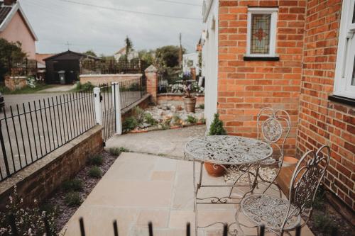 a patio with a table and chairs and a building at Hazel's in Leiston