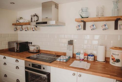 a kitchen with a counter top with a stove top oven at Hazel's in Leiston
