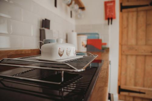 a tea set on top of a stove in a kitchen at Hazel's in Leiston