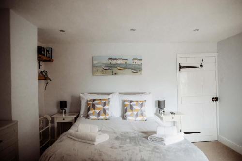 a bedroom with a large white bed with two tables at Hazel's in Leiston
