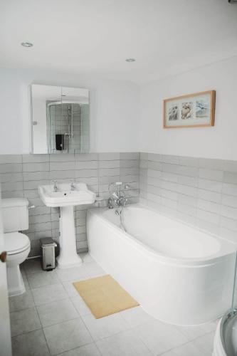 a bathroom with a tub and a sink and a toilet at Hazel's in Leiston