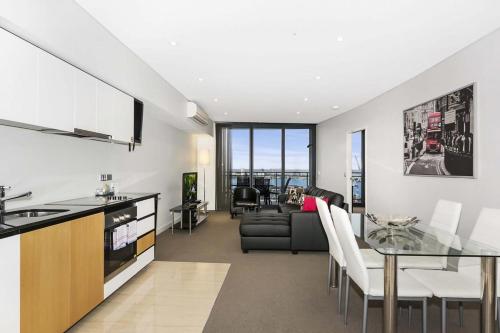 a kitchen and living room with a table and a couch at Astra Apartments Perth - Zenith in Perth