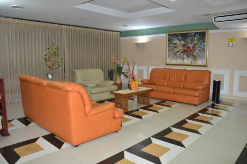 a waiting room with two orange chairs and a table at Maicao Internacional in Maicao