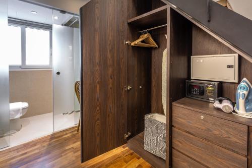 a bathroom with a wooden cabinet with a microwave at Heritage Collection on Seah - A Digital Hotel in Singapore