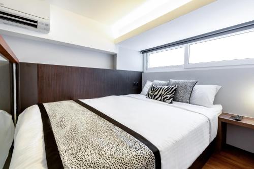 a bedroom with a large bed and a window at Heritage Collection on Seah - Mobile App Check-In in Singapore