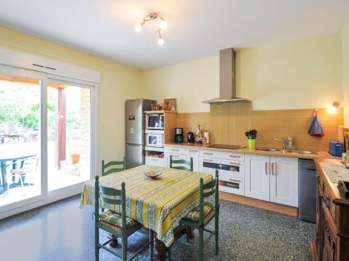 cocina con mesa con sillas y ventana en Villa Coste Belle in the heart of nature, en Vers Pont du Gard