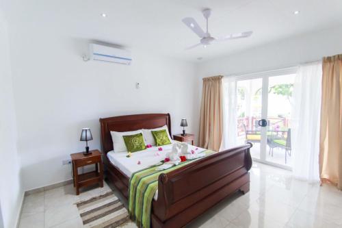 1 dormitorio con cama y ventana grande en Coco Blanche, en Anse Royale