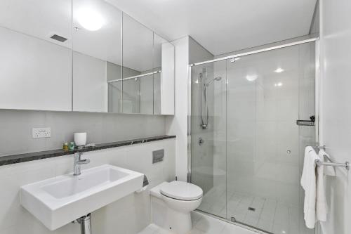 a bathroom with a toilet and a sink and a shower at Astra Apartments Perth CBD in Perth