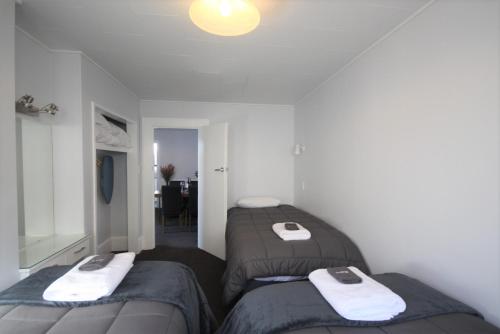 a bedroom with two beds with towels on them at Beach Lodge Motels in Dunedin