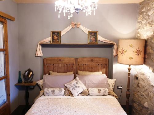 a bedroom with a bed and a chandelier at Il Pievano B&B in Campiglia Marittima