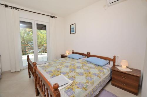 a bedroom with a bed with a table and a window at Apartment Anica in Štivan