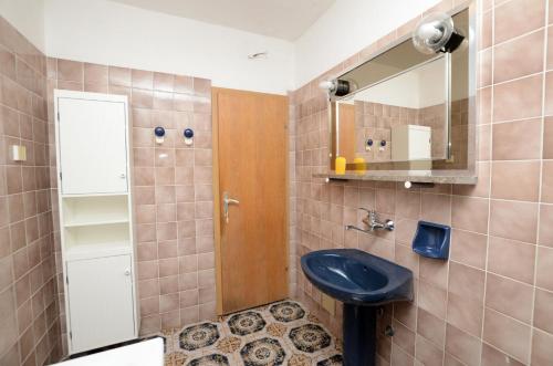 a bathroom with a blue sink and a mirror at Apartment Anica in Štivan