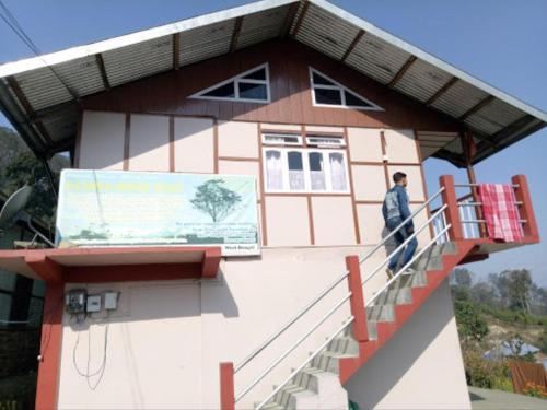 a man standing on the balcony of a house at VAMOOSE ALISHA SILKROUTE in Pedong