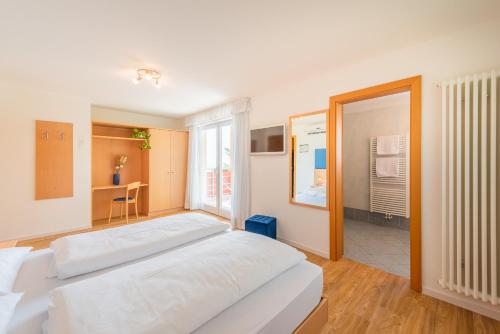 1 dormitorio con cama grande y ventana grande en B&B Garni Erika, en Termeno
