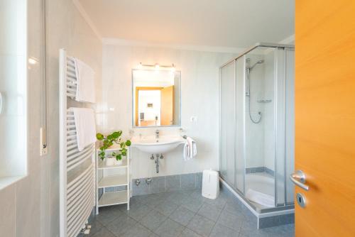 a bathroom with a sink and a shower at B&B Garni Erika in Termeno