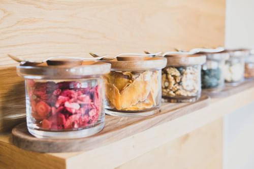 a row of jars of food on a shelf at Boutique Hotel Edelmanns in Kematen in Tirol