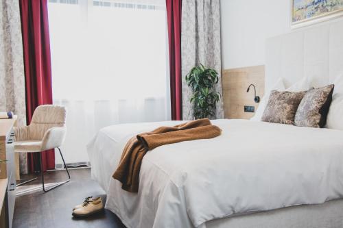 a bedroom with a large bed with a blanket on it at Boutique Hotel Edelmanns in Kematen in Tirol
