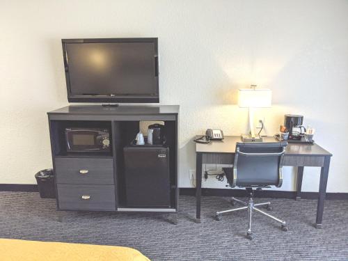 a desk with a television and a desk with a chair at Quality Inn & Suites South San Jose - Morgan Hill in Morgan Hill