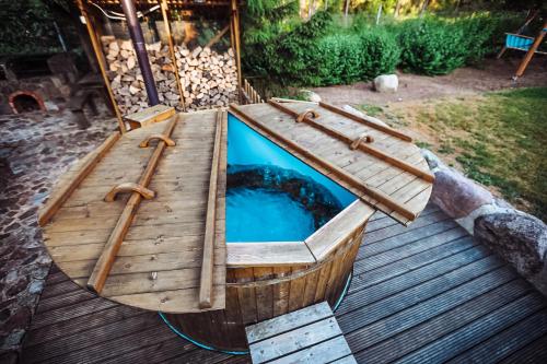 un bateau en bois avec une piscine sur une terrasse dans l'établissement Leśny Zakątek balia kąpielowa ognisko sauna basen rowery w cenie pobytu, à Kruszyniany