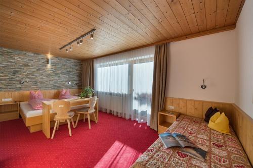 una camera con letto, tavolo e divano di Haus Moostal a Sankt Anton am Arlberg
