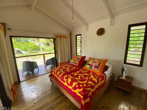 a bedroom with a bed and a large window at Moorea Chill House And Beach in Teavaro