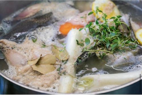 a pot of soup with meat and vegetables in it at Grand Hotel Flekkefjord in Flekkefjord