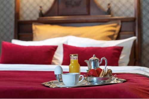 a tray of food on a bed with a plate of food at Grand Hotel Flekkefjord in Flekkefjord