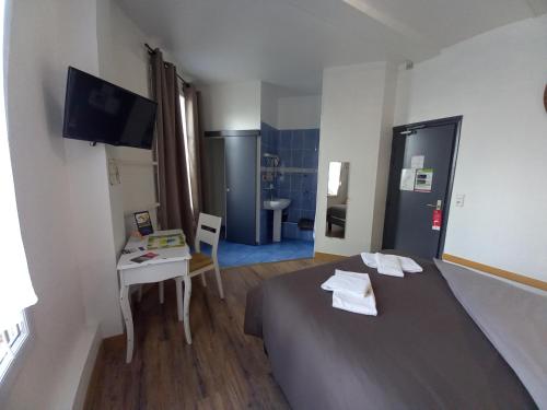 a hotel room with a bed and a table and a television at Le Terminus fasthotel soissons centre in Soissons