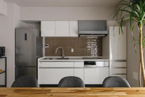 a kitchen with a sink and a refrigerator at THREE in Tokyo