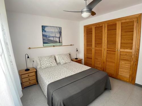 a bedroom with a bed and a wooden closet at Blanes old town: 2 blocks/2 min walk to the beach in Blanes