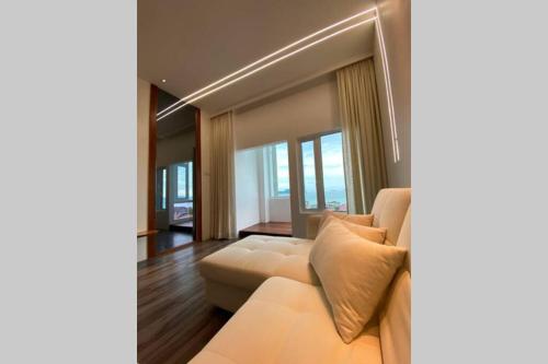 a living room with a white couch and windows at Ikiru Japanese Tatami Convenient Seaview Apartment in Kuah