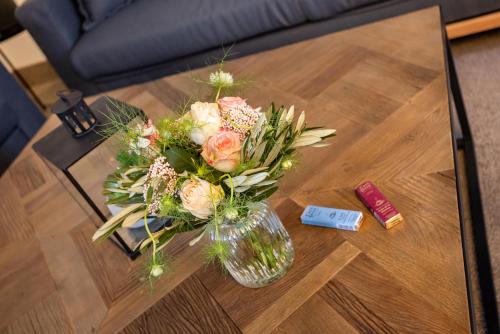 a vase of flowers sitting on a table at maakt Apartments in Stralsund