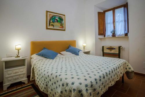 ein Schlafzimmer mit einem großen Bett mit blauen Kissen in der Unterkunft Fattoria Poggio di Fiesole in Fiesole