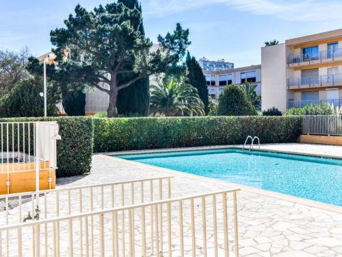 a swimming pool in front of a building at T3 150 m de la plage, climatisation, piscine et parking privatif - Le Lavandou in Le Lavandou