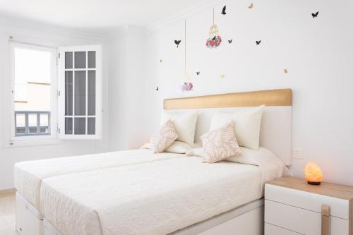 a white bedroom with a large bed with white walls at Home2Book Center Apartment Santa Cruz, Wifi in Santa Cruz de Tenerife