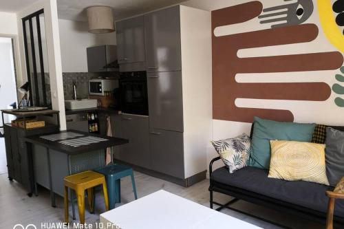 a living room with a couch and a kitchen at Appartement avec Jardin privatif centre ville in Hyères