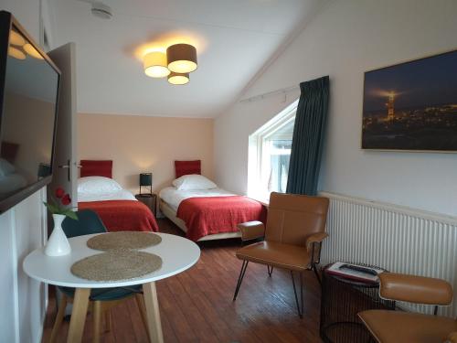a small room with two beds and a table and a table at Bed and Breakfast Oosterpark in Harlingen
