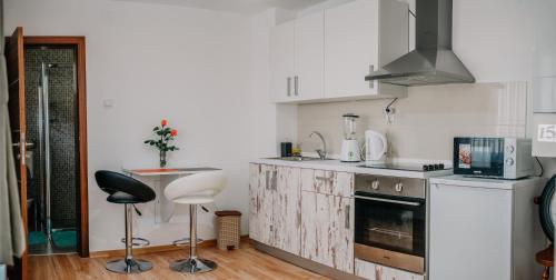 a kitchen with white cabinets and a counter top at Kuca Magnolija in Nuštar