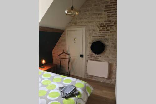 a bedroom with a bed and a brick wall at La Terrasse du Chevalier d'Eon - Loft à TONNERRE in Tonnerre