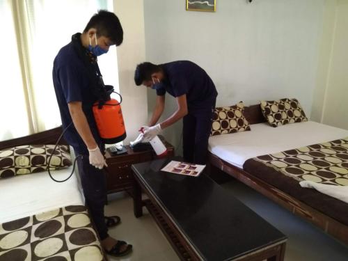 two men are standing in a room with beds at Hotel Silver Sand in Trivandrum