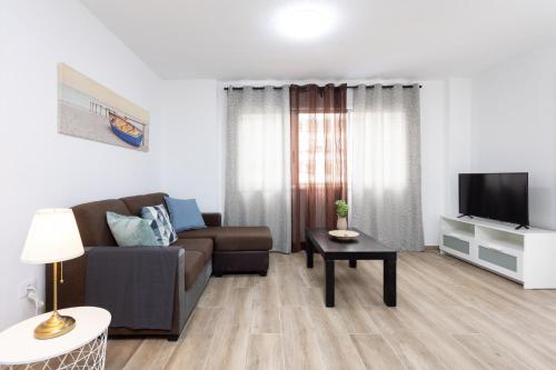 ein Wohnzimmer mit Sofa und Fernseher in der Unterkunft Home2Book Charming Apartment Santa Cruz, Wifi in Santa Cruz de Tenerife