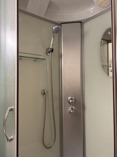 a shower with a shower head in a bathroom at Palūšės Kempingas (kambariai) in Palūšė