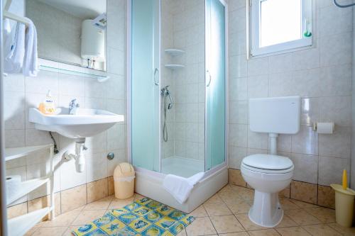 a bathroom with a shower and a toilet and a sink at Apartments Valentin in Privlaka