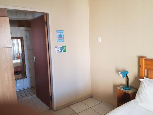 a bedroom with a door leading to a bathroom at Louhallas Accommodation in Edenvale