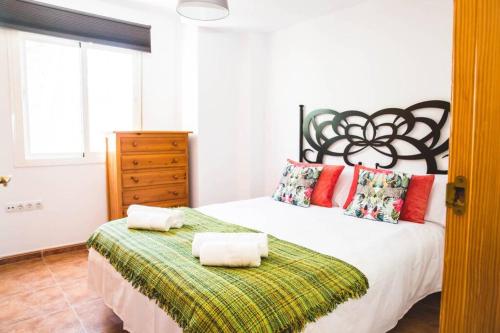 Apartamento con vistas al mar en Pedregalejo playa في مالقة: غرفة نوم عليها سرير وفوط